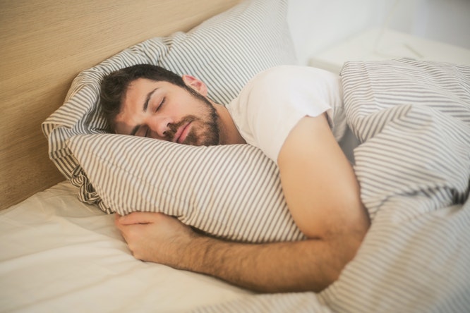 Man hugging his pillow while sleeping