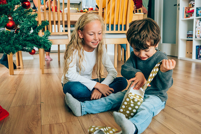 a brother and sister opening a holiday present