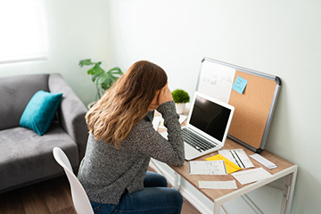 Woman sitting in front of her laptop stressed about bills