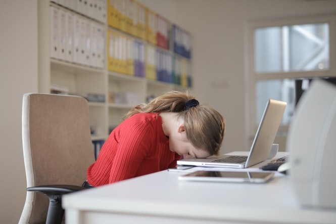 Woman with head down on her laptop