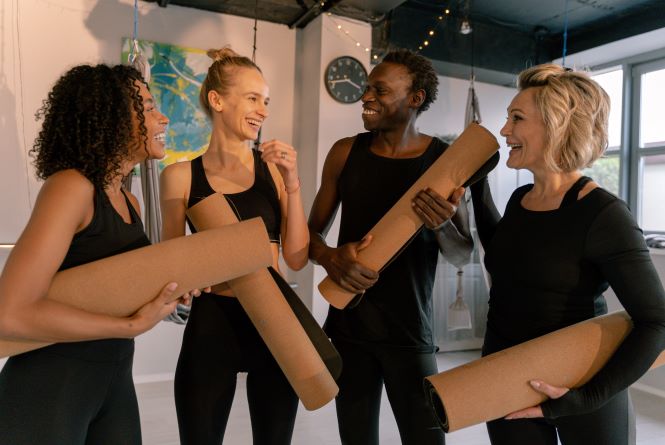 group of people talking in a yoga studio