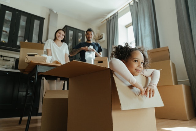 Family unpacking boxes with children