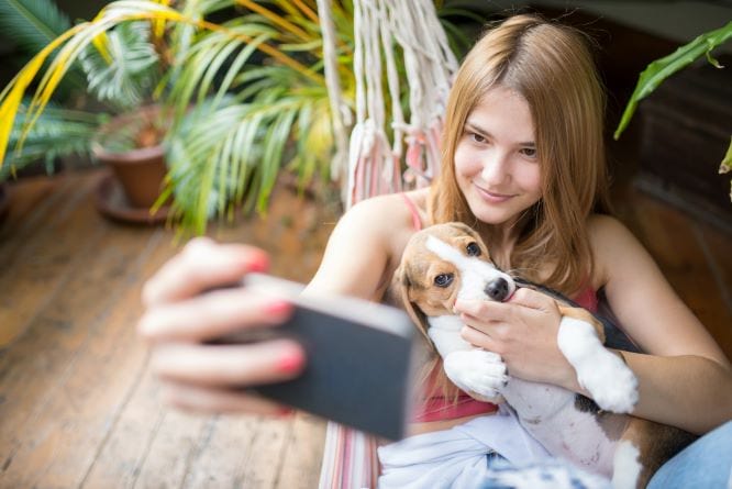 young woman taking a selfie with her puppy