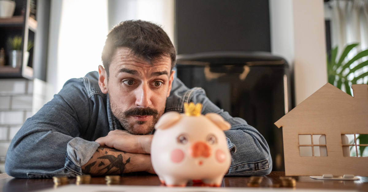 Man looking at pink piggy bank 