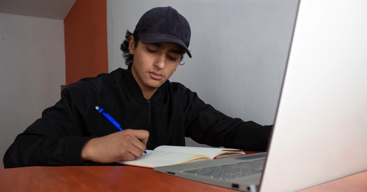 Woman smiling at laptop using online banking for share certificate